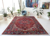 Antique Persian area rug in a living room setting, pile rug, vintage rug, portland, rug shop, bright colors, wild shaman, soft rug, bold color, Portland, Oregon, rug store, rug shop, local shop, antique rug, Persian rug, handmade rug, wool rug, distressed rug