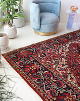 Antique Persian area rug in a living room setting, pile rug, vintage rug, portland, rug shop, bright colors, wild shaman, soft rug, bold color, Portland, Oregon, rug store, rug shop, local shop, antique rug, Persian rug, handmade rug, wool rug, distressed rug