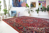 Antique Persian area rug in a living room setting, pile rug, vintage rug, portland, rug shop, bright colors, wild shaman, soft rug, bold color, Portland, Oregon, rug store, rug shop, local shop, antique rug, Persian rug, handmade rug, wool rug, distressed rug