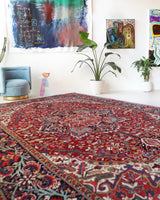 Antique Persian area rug in a living room setting, pile rug, vintage rug, portland, rug shop, bright colors, wild shaman, soft rug, bold color, Portland, Oregon, rug store, rug shop, local shop, antique rug, Persian rug, handmade rug, wool rug, distressed rug