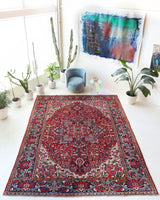 Antique Persian area rug in a living room setting, pile rug, vintage rug, portland, rug shop, bright colors, wild shaman, soft rug, bold color, Portland, Oregon, rug store, rug shop, local shop, antique rug, Persian rug, handmade rug, wool rug, distressed rug