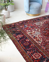 Antique Persian area rug in a living room setting, pile rug, vintage rug, portland, rug shop, bright colors, wild shaman, soft rug, bold color, Portland, Oregon, rug store, rug shop, local shop, antique rug, Persian rug, handmade rug, wool rug, distressed rug