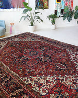 Antique Persian area rug in a living room setting, pile rug, vintage rug, portland, rug shop, bright colors, wild shaman, soft rug, bold color, Portland, Oregon, rug store, rug shop, local shop, antique rug, Persian rug, handmade rug, wool rug, distressed rug