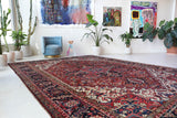 Antique Persian area rug in a living room setting, pile rug, vintage rug, portland, rug shop, bright colors, wild shaman, soft rug, bold color, Portland, Oregon, rug store, rug shop, local shop, antique rug, Persian rug, handmade rug, wool rug, distressed rug