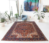 Antique Persian area rug in a living room setting, pile rug, vintage rug, portland, rug shop, bright colors, wild shaman, soft rug, bold color, Portland, Oregon, rug store, rug shop, local shop, antique rug, Persian rug, handmade rug, wool rug, distressed rug