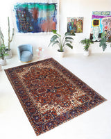 Antique Persian area rug in a living room setting, pile rug, vintage rug, portland, rug shop, bright colors, wild shaman, soft rug, bold color, Portland, Oregon, rug store, rug shop, local shop, antique rug, Persian rug, handmade rug, wool rug, distressed rug