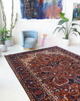 Antique Persian area rug in a living room setting, pile rug, vintage rug, portland, rug shop, bright colors, wild shaman, soft rug, bold color, Portland, Oregon, rug store, rug shop, local shop, antique rug, Persian rug, handmade rug, wool rug, distressed rug