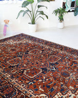 Antique Persian area rug in a living room setting, pile rug, vintage rug, portland, rug shop, bright colors, wild shaman, soft rug, bold color, Portland, Oregon, rug store, rug shop, local shop, antique rug, Persian rug, handmade rug, wool rug, distressed rug