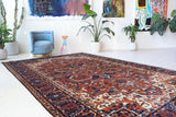 Antique Persian area rug in a living room setting, pile rug, vintage rug, portland, rug shop, bright colors, wild shaman, soft rug, bold color, Portland, Oregon, rug store, rug shop, local shop, antique rug, Persian rug, handmade rug, wool rug, distressed rug