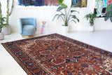 Antique Persian area rug in a living room setting, pile rug, vintage rug, portland, rug shop, bright colors, wild shaman, soft rug, bold color, Portland, Oregon, rug store, rug shop, local shop, antique rug, Persian rug, handmade rug, wool rug, distressed rug