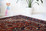 Antique Persian area rug in a living room setting, pile rug, vintage rug, portland, rug shop, bright colors, wild shaman, soft rug, bold color, Portland, Oregon, rug store, rug shop, local shop, antique rug, Persian rug, handmade rug, wool rug, distressed rug