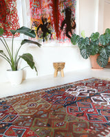 Vintage kilim rug in living room setting, old rug, antique rug, pastel colors, faded colors, Turkish rug, vintage rug, soft rug, Portland, Oregon, rug store, rug shop, local shop, earthy tones, earthy colors, warm colors