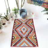 Vintage kilim rug in room decor setting, old rug, antique rug, pastel colors, faded colors, Turkish rug, vintage rug, soft rug, Portland, Oregon, rug store, rug shop, local shop,  antique kilim rug, bold colors, bright colors, faded colors