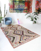 Vintage kilim rug in living room setting, old rug, antique rug, pastel colors, faded colors, Turkish rug, vintage rug, soft rug, Portland, Oregon, rug store, rug shop, local shop, earthy tones, earthy colors, warm colors