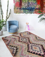 Vintage kilim rug in living room setting, old rug, antique rug, pastel colors, faded colors, Turkish rug, vintage rug, soft rug, Portland, Oregon, rug store, rug shop, local shop, earthy tones, earthy colors, warm colors