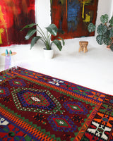 Vintage kilim rug in living room setting, bright colors, wild shaman, soft rug, bold color, Portland, Oregon, rug store, rug shop, local shop, vintage rug, modern kilim, warm colors, antique rug, antique kilim