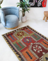 Vintage kilim rug in living room setting, old rug, antique rug, pastel colors, faded colors, Turkish rug, vintage rug, soft rug, Portland, Oregon, rug store, rug shop, local shop, earthy tones, earthy colors, warm colors