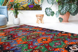 Vintage kilim rug in living room setting, bright colors, wild shaman, soft rug, bold color, Portland, Oregon, rug store, rug shop, local shop, vintage rug, modern kilim, warm colors, antique kilim rug