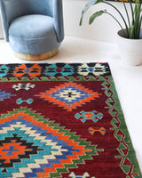 Vintage kilim rug in room decor setting, old rug, antique rug, pastel colors, faded colors, Turkish rug, vintage rug, soft rug, Portland, Oregon, rug store, rug shop, local shop, antique kilim rug, bold colors, bright colors, faded colors