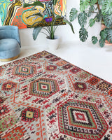 Vintage kilim rug in living room setting, old rug, antique rug, pastel colors, faded colors, Turkish rug, vintage rug, soft rug, Portland, Oregon, rug store, rug shop, local shop, earthy tones, earthy colors, warm colors