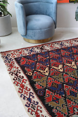 Vintage kilim rug in living room setting, bright colors, wild shaman, soft rug, bold color, Portland, Oregon, rug store, rug shop, local shop, vintage rug, modern kilim, warm colors, antique rug, antique kilim