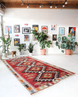 Vintage kilim rug in living room setting, old rug, antique rug, pastel colors, faded colors, Turkish rug, vintage rug, soft rug, Portland, Oregon, rug store, rug shop, local shop, earthy tones, earthy colors, warm colors