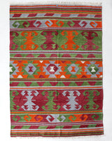 Vintage kilim rug in living room setting, old rug, antique rug, pastel colors, faded colors, Turkish rug, vintage rug, soft rug, Portland, Oregon, rug store, rug shop, local shop, earthy tones, earthy colors, warm colors