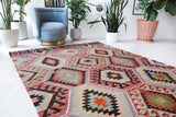 Vintage kilim rug in room decor setting, old rug, antique rug, pastel colors, faded colors, Turkish rug, vintage rug, soft rug, Portland, Oregon, rug store, rug shop, local shop, bold colors, bright colors, faded colors