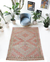 Vintage kilim rug in living room setting, old rug, antique rug, pastel colors, faded colors, Turkish rug, vintage rug, soft rug, Portland, Oregon, rug store, rug shop, local shop, earthy tones, earthy colors, warm colors