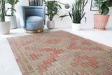 Vintage kilim rug in living room setting, old rug, antique rug, pastel colors, faded colors, Turkish rug, vintage rug, soft rug, Portland, Oregon, rug store, rug shop, local shop, earthy tones, earthy colors, warm colors