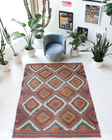 Vintage kilim rug in room decor setting, old rug, antique rug, pastel colors, faded colors, Turkish rug, vintage rug, soft rug, Portland, Oregon, rug store, rug shop, local shop, bold colors, bright colors, faded colors