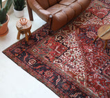 Antique Persian area rug in a living room setting, pile rug, vintage rug, portland, rug shop, bright colors, wild shaman, soft rug, bold color, Portland, Oregon, rug store, rug shop, local shop, antique rug, Persian rug, handmade rug, wool rug, distressed rug