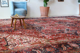 Antique Persian area rug in a living room setting, pile rug, vintage rug, portland, rug shop, bright colors, wild shaman, soft rug, bold color, Portland, Oregon, rug store, rug shop, local shop, antique rug, Persian rug, handmade rug, wool rug, distressed rug