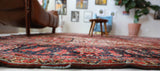 Antique Persian area rug in a living room setting, pile rug, vintage rug, portland, rug shop, bright colors, wild shaman, soft rug, bold color, Portland, Oregon, rug store, rug shop, local shop, antique rug, Persian rug, handmade rug, wool rug, distressed rug