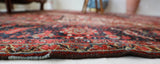 Antique Persian area rug in a living room setting, pile rug, vintage rug, portland, rug shop, bright colors, wild shaman, soft rug, bold color, Portland, Oregon, rug store, rug shop, local shop, antique rug, Persian rug, handmade rug, wool rug, distressed rug