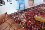Antique Persian area rug in a living room setting, pile rug, vintage rug, portland, rug shop, bright colors, wild shaman, soft rug, bold color, Portland, Oregon, rug store, rug shop, local shop, antique rug, Persian rug, handmade rug, wool rug, distressed rug