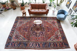Antique Persian area rug in a living room setting, pile rug, vintage rug, portland, rug shop, bright colors, wild shaman, soft rug, bold color, Portland, Oregon, rug store, rug shop, local shop, antique rug, Persian rug, handmade rug, wool rug, distressed rug