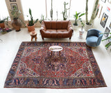 Antique Persian area rug in a living room setting, pile rug, vintage rug, portland, rug shop, bright colors, wild shaman, soft rug, bold color, Portland, Oregon, rug store, rug shop, local shop, antique rug, Persian rug, handmade rug, wool rug, distressed rug