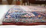 Antique Persian area rug in a living room setting, pile rug, vintage rug, portland, rug shop, bright colors, wild shaman, soft rug, bold color, Portland, Oregon, rug store, rug shop, local shop, antique rug, Persian rug, handmade rug, wool rug, distressed rug