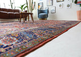 Antique Persian area rug in a living room setting, pile rug, vintage rug, portland, rug shop, bright colors, wild shaman, soft rug, bold color, Portland, Oregon, rug store, rug shop, local shop, antique rug, Persian rug, handmade rug, wool rug, distressed rug