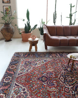 Antique Persian area rug in a living room setting, pile rug, vintage rug, portland, rug shop, bright colors, wild shaman, soft rug, bold color, Portland, Oregon, rug store, rug shop, local shop, antique rug, Persian rug, handmade rug, wool rug, distressed rug