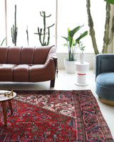 Antique Persian area rug in a living room setting, pile rug, vintage rug, portland, rug shop, bright colors, wild shaman, soft rug, bold color, Portland, Oregon, rug store, rug shop, local shop, antique rug, Persian rug, handmade rug, wool rug, distressed rug