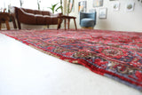 Antique Persian area rug in a living room setting, pile rug, vintage rug, portland, rug shop, bright colors, wild shaman, soft rug, bold color, Portland, Oregon, rug store, rug shop, local shop, antique rug, Persian rug, handmade rug, wool rug, distressed rug
