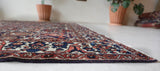 Antique Persian area rug in a living room setting, pile rug, vintage rug, portland, rug shop, bright colors, wild shaman, soft rug, bold color, Portland, Oregon, rug store, rug shop, local shop, antique rug, Persian rug, handmade rug, wool rug, distressed rug
