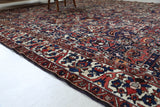 Antique Persian area rug in a living room setting, pile rug, vintage rug, portland, rug shop, bright colors, wild shaman, soft rug, bold color, Portland, Oregon, rug store, rug shop, local shop, antique rug, Persian rug, handmade rug, wool rug, distressed rug
