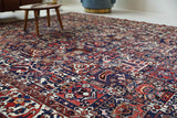 Antique Persian area rug in a living room setting, pile rug, vintage rug, portland, rug shop, bright colors, wild shaman, soft rug, bold color, Portland, Oregon, rug store, rug shop, local shop, antique rug, Persian rug, handmade rug, wool rug, distressed rug