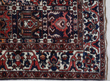 Antique Persian area rug in a living room setting, pile rug, vintage rug, portland, rug shop, bright colors, wild shaman, soft rug, bold color, Portland, Oregon, rug store, rug shop, local shop, antique rug, Persian rug, handmade rug, wool rug, distressed rug
