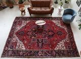Antique Persian area rug in a living room setting, pile rug, vintage rug, portland, rug shop, bright colors, wild shaman, soft rug, bold color, Portland, Oregon, rug store, rug shop, local shop, antique rug, Persian rug, handmade rug, wool rug, distressed rug