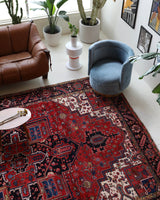 Antique Persian area rug in a living room setting, pile rug, vintage rug, portland, rug shop, bright colors, wild shaman, soft rug, bold color, Portland, Oregon, rug store, rug shop, local shop, antique rug, Persian rug, handmade rug, wool rug, distressed rug