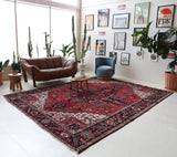 Antique Persian area rug in a living room setting, pile rug, vintage rug, portland, rug shop, bright colors, wild shaman, soft rug, bold color, Portland, Oregon, rug store, rug shop, local shop, antique rug, Persian rug, handmade rug, wool rug, distressed rug